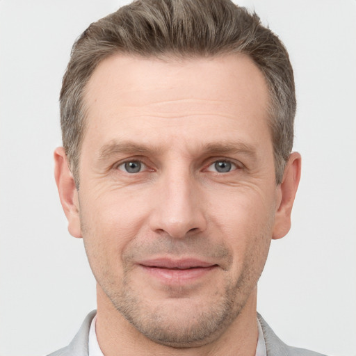 Joyful white adult male with short  brown hair and grey eyes