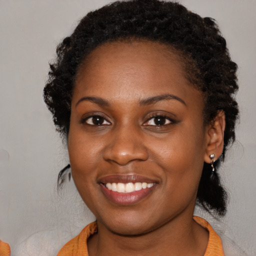 Joyful black young-adult female with medium  brown hair and brown eyes