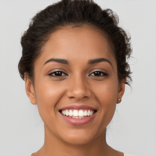 Joyful latino young-adult female with short  brown hair and brown eyes