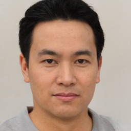 Joyful asian young-adult male with short  black hair and brown eyes