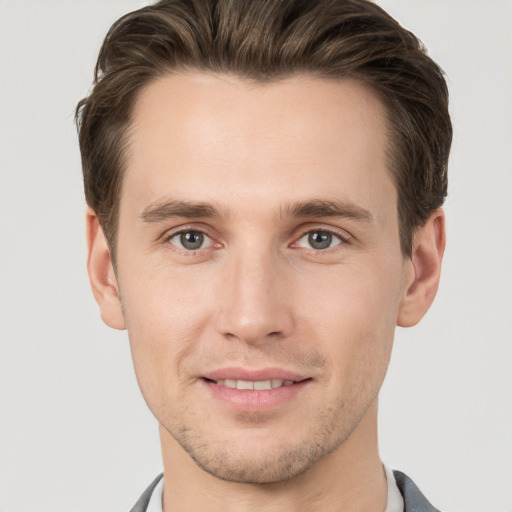 Joyful white young-adult male with short  brown hair and grey eyes