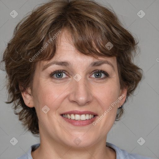 Joyful white adult female with medium  brown hair and blue eyes