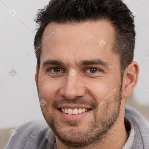 Joyful white adult male with short  brown hair and brown eyes