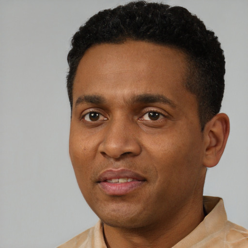Joyful black young-adult male with short  black hair and brown eyes