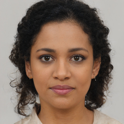 Joyful black young-adult female with long  brown hair and brown eyes