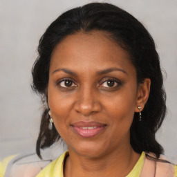 Joyful black adult female with medium  brown hair and brown eyes