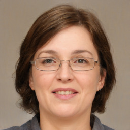 Joyful white adult female with medium  brown hair and grey eyes