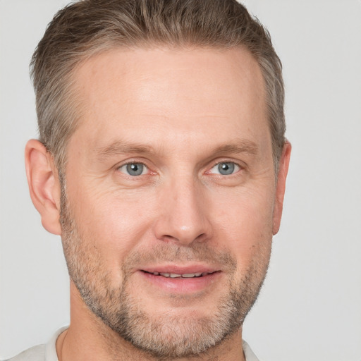 Joyful white adult male with short  brown hair and grey eyes