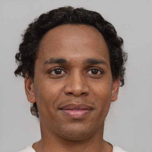 Joyful black adult male with short  brown hair and brown eyes