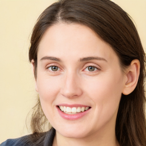 Joyful white young-adult female with long  brown hair and brown eyes