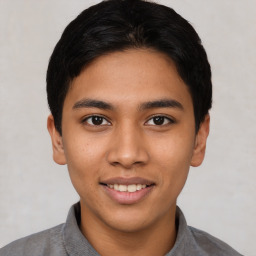 Joyful latino young-adult male with short  black hair and brown eyes