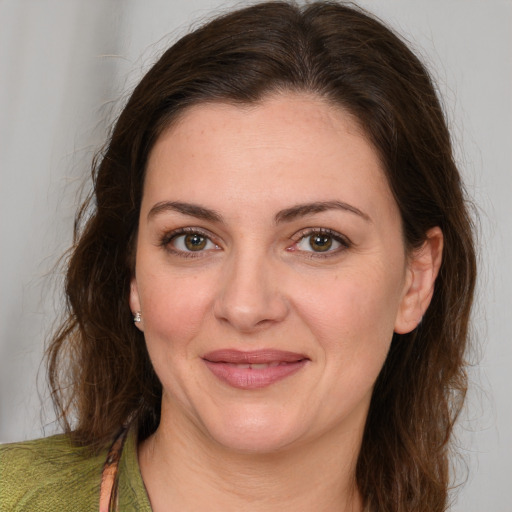 Joyful white young-adult female with medium  brown hair and green eyes