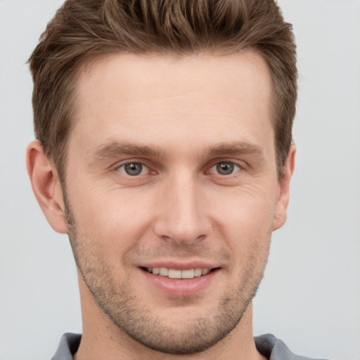 Joyful white young-adult male with short  brown hair and grey eyes