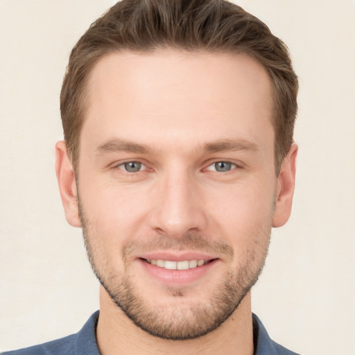 Joyful white young-adult male with short  brown hair and grey eyes