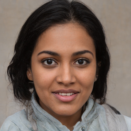 Joyful latino young-adult female with medium  brown hair and brown eyes