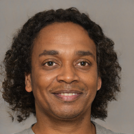 Joyful black adult male with short  brown hair and brown eyes