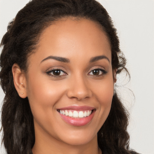 Joyful latino young-adult female with long  brown hair and brown eyes