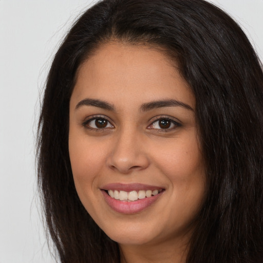 Joyful white young-adult female with long  brown hair and brown eyes