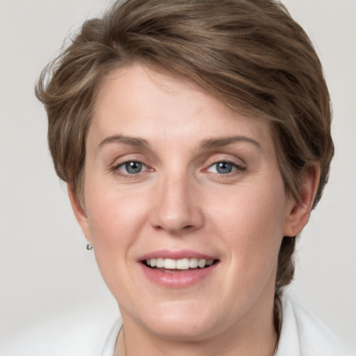 Joyful white young-adult female with medium  brown hair and grey eyes