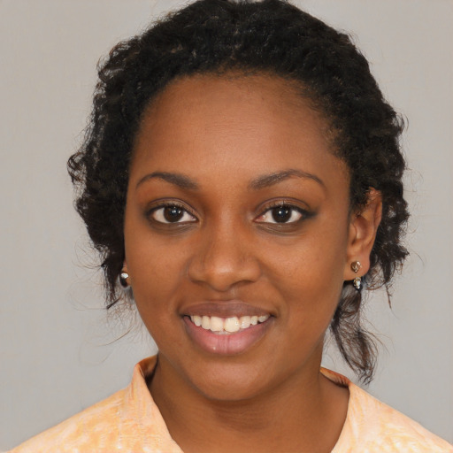 Joyful black young-adult female with medium  black hair and brown eyes