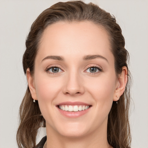 Joyful white young-adult female with long  brown hair and grey eyes