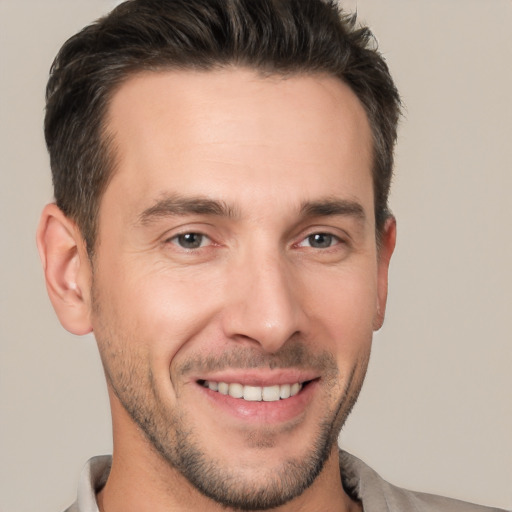 Joyful white young-adult male with short  brown hair and brown eyes