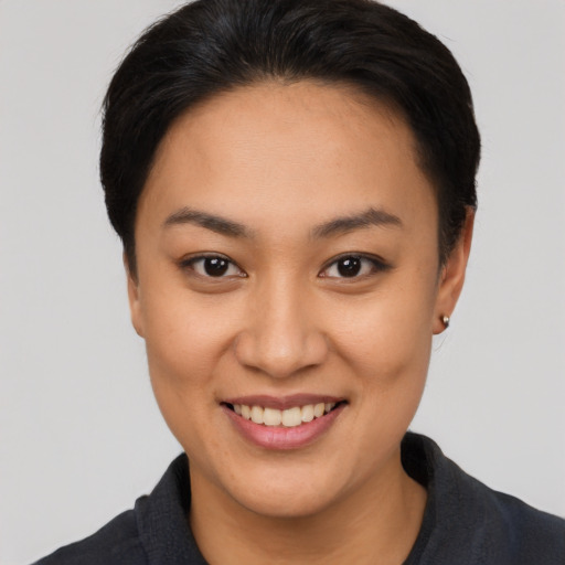 Joyful asian young-adult female with short  brown hair and brown eyes