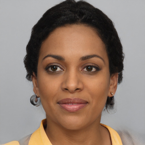 Joyful black young-adult female with short  brown hair and brown eyes