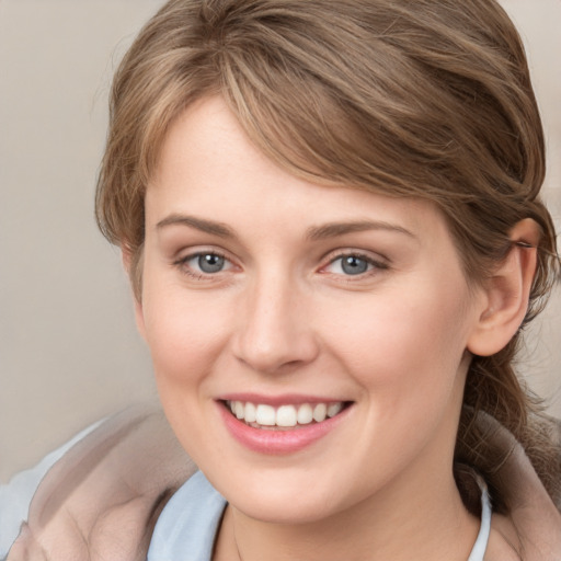 Joyful white young-adult female with medium  brown hair and grey eyes