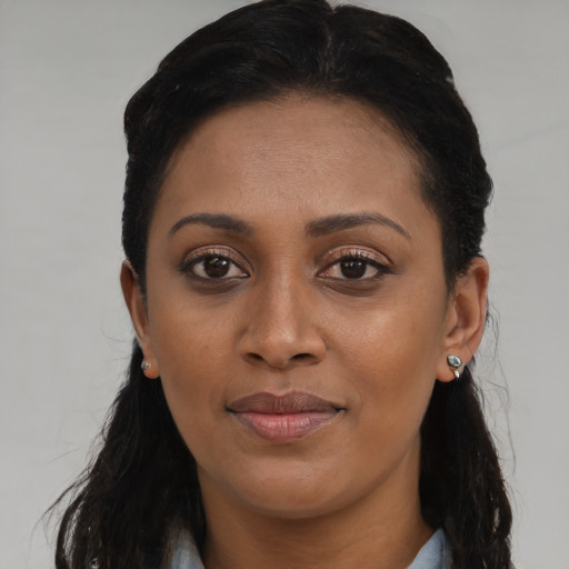 Joyful black young-adult female with long  brown hair and brown eyes
