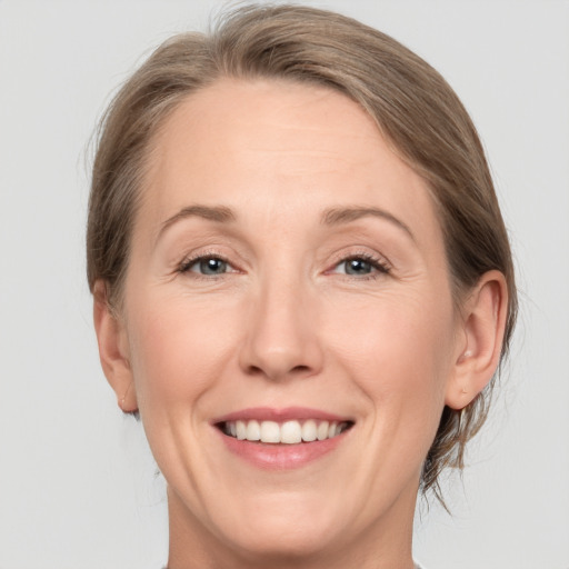 Joyful white adult female with medium  brown hair and grey eyes