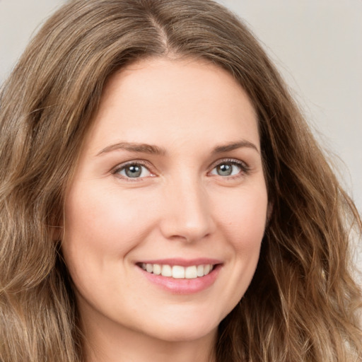 Joyful white young-adult female with long  brown hair and green eyes