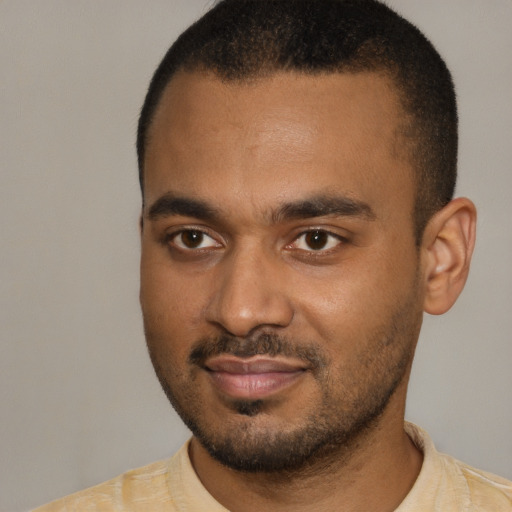 Joyful black young-adult male with short  black hair and brown eyes