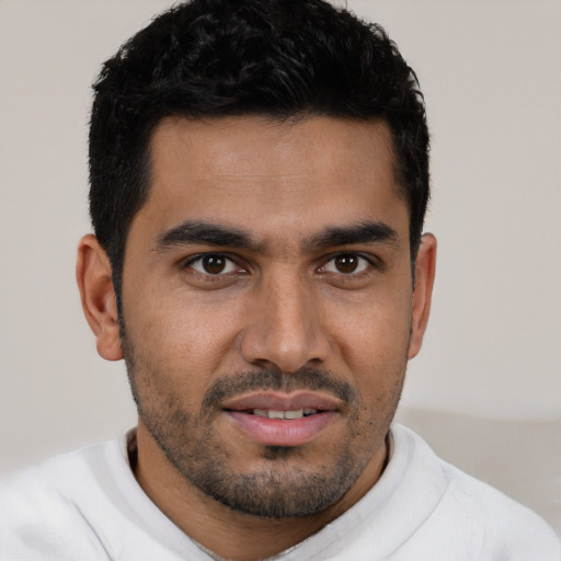 Joyful latino young-adult male with short  black hair and brown eyes
