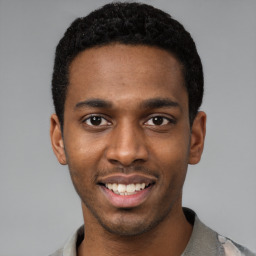 Joyful black young-adult male with short  black hair and brown eyes