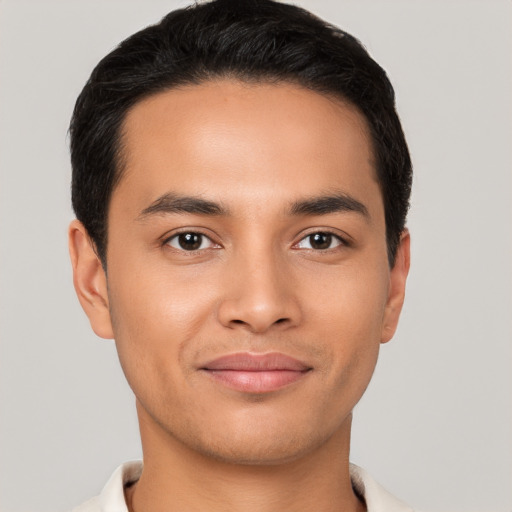 Joyful latino young-adult male with short  brown hair and brown eyes