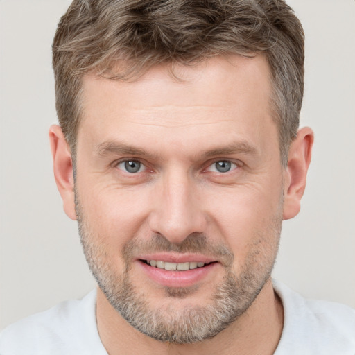 Joyful white adult male with short  brown hair and brown eyes