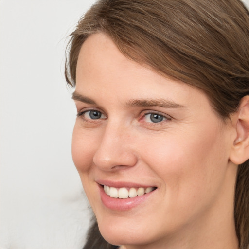 Joyful white young-adult female with medium  brown hair and grey eyes