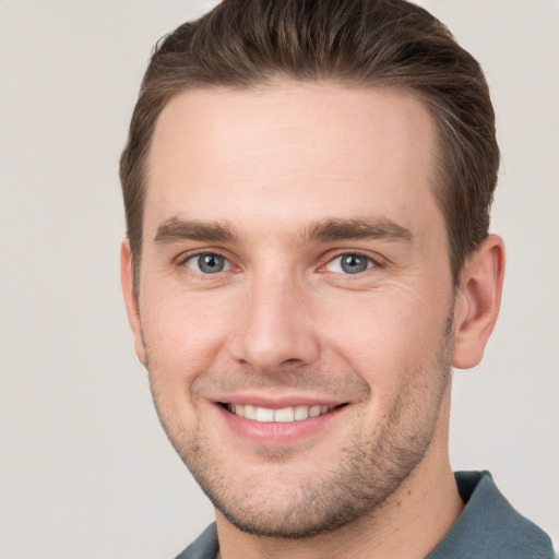 Joyful white young-adult male with short  brown hair and grey eyes