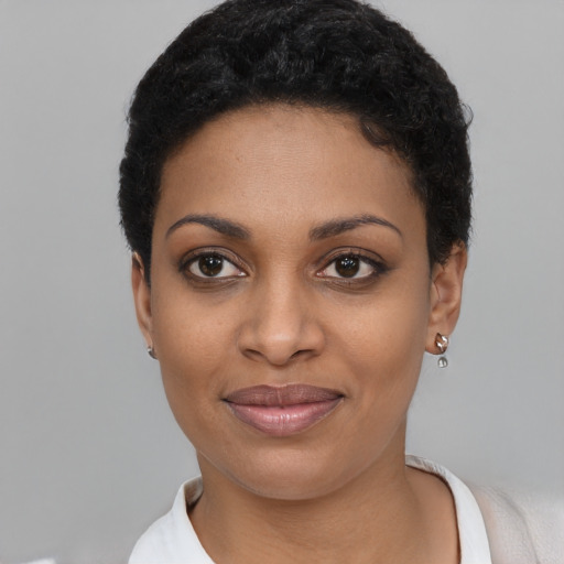 Joyful black young-adult female with short  black hair and brown eyes
