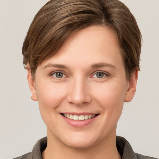 Joyful white young-adult female with short  brown hair and grey eyes