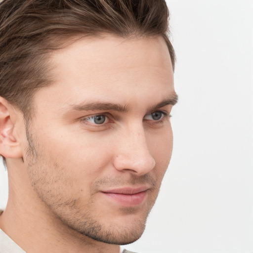 Joyful white young-adult male with short  brown hair and grey eyes