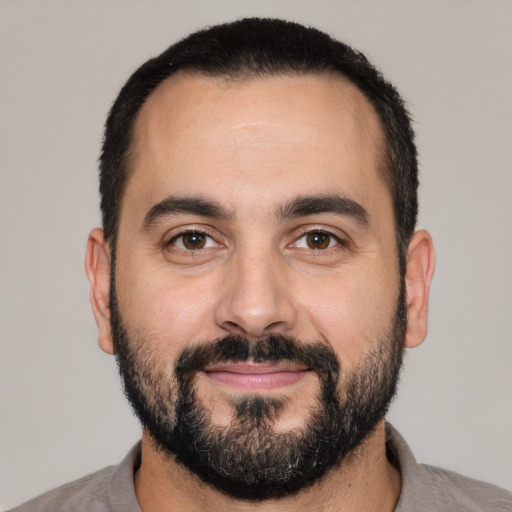 Joyful white adult male with short  black hair and brown eyes