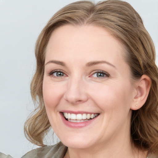 Joyful white young-adult female with medium  brown hair and blue eyes