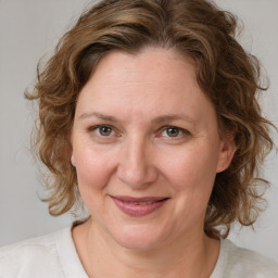 Joyful white adult female with medium  brown hair and blue eyes