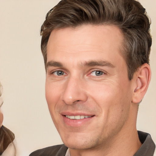 Joyful white adult male with short  brown hair and grey eyes