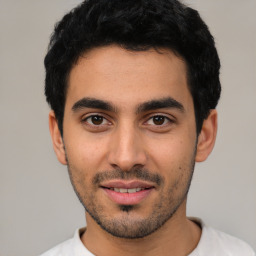 Joyful latino young-adult male with short  black hair and brown eyes