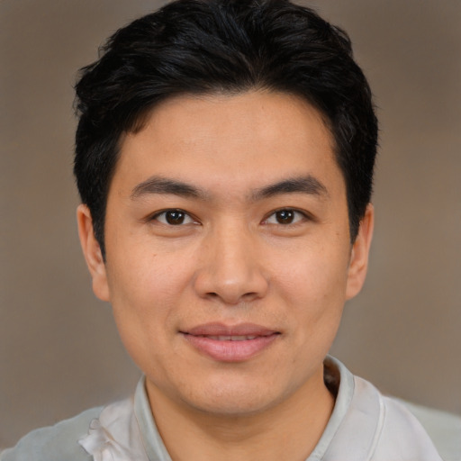 Joyful latino young-adult male with short  brown hair and brown eyes