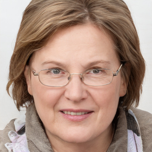 Joyful white adult female with medium  brown hair and blue eyes