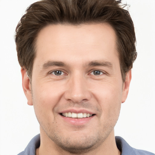 Joyful white young-adult male with short  brown hair and grey eyes